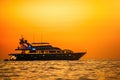 Golden romantic sunset on private modern luxury yacht anchored at sea - luxury holidays and travel concept. A red