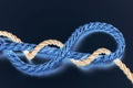 Golden rope woven with blue rope over dark blue background