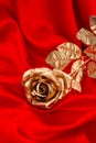 Golden rose flower over smooth red satin Royalty Free Stock Photo