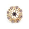 Gold round brooch with purple diamonds isolated on white