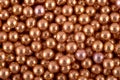 Golden round dots candies abstract background, copy space. Sweets texture. Top view, flat lay Royalty Free Stock Photo