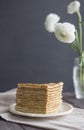 Golden Russian pancakes grey napkin dark background Ranunkulyus buttercup bouquet