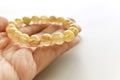 Golden rutilated quartz bracelet on hand.