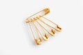 Golden safety pins on white background, flat lay Royalty Free Stock Photo