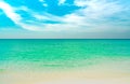 Golden sand beach by the sea with emerald green sea water and blue sky and white clouds. Summer vacation on tropical paradise Royalty Free Stock Photo