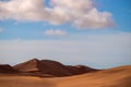 Golden sand dune 7 and white clouds on a sunny day in the Namib desert. Fantastic place for travelers and photographers Royalty Free Stock Photo