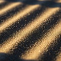 Golden sand grains form undulating patterns with alternating light and shadow, creating a textured Royalty Free Stock Photo