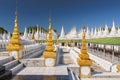 Golden Sandamuni Pagoda with row of white pagodas. Amazing architecture of Buddhist Temples at Mandalay, Myanmar