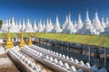 Golden Sandamuni Pagoda with row of white pagodas. Amazing architecture of Buddhist Temples at Mandalay, Myanmar