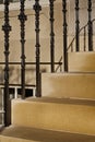 Golden sandstone steps and ornate black stair banister posts