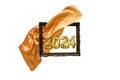 Golden satin cloth flying and unveiling 2024 tin foil balloons number thru a wooden frame, abstract new year background Royalty Free Stock Photo