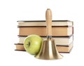 Golden school bell with wooden handle, apple and stack of books on white background Royalty Free Stock Photo