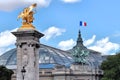 Golden sculpture on the Alexander III bridge with Grand Palais building in the background Royalty Free Stock Photo