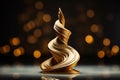 a golden sculpture of a wave on a black background
