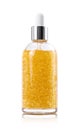 Golden serum in glass bottle on white background