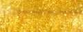 Golden shiny background, copy space for your Christmas greetings. Banner with defocused lights, bright yellow bokeh. Shimmer of Royalty Free Stock Photo