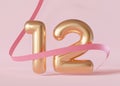 Golden shiny number twelve on pink background with ribbon. Symbol 12. Invitation for a twelfth birthday party or