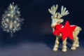 Golden shiny reindeer figurine with a christmas tree on a dark background. Christmas background Royalty Free Stock Photo