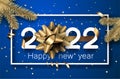 Golden 2022 sign with bow in square frame with confetti