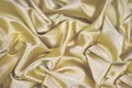 Golden silk satin fabric. Luxurious bright background for your design. Beautiful folds on shiny gold fabric.