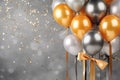 Golden and silver gray metallic glitter balloons and confetti on glistering background. Birthday, holiday or party background. Royalty Free Stock Photo