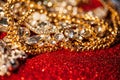 Golden and silver jewelry on red shiny glitter background Royalty Free Stock Photo