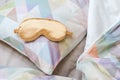 Golden sleeping eye mask on the bed, top view. Good night, flight and travel concept. Sweet dreams, siesta, insomnia, relaxation,
