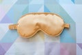 Golden sleeping eye mask on the bed, top view. Good night, flight and travel concept. Sweet dreams, siesta, insomnia, relaxation,