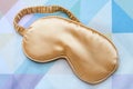 Golden sleeping eye mask on the bed, top view. Good night, flight and travel concept. Sweet dreams, siesta, insomnia, relaxation,