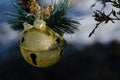 Golden Sleigh Bell Christmas Ornament Decorating an Outdoor Tree Royalty Free Stock Photo