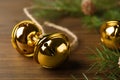 Golden sleigh bells and fir branch on wooden table, closeup Royalty Free Stock Photo