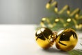 Golden sleigh bells on white table, closeup. Space for text Royalty Free Stock Photo