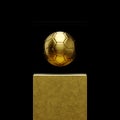 Golden soccer ball under glass on golden podium, exhibition sale, cup or trophy Royalty Free Stock Photo