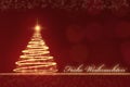 Golden sparkling Christmas tree against a red blurred background with golden snowflakes