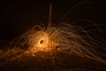 Golden sparks fly at night in winter snow through glowing steel wool spun in a circle, Germany Royalty Free Stock Photo
