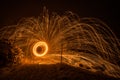 Golden sparks fly at night in winter snow through glowing steel wool spun in a circle, Germany Royalty Free Stock Photo