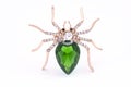 Golden spider with a big green stone isolated on white