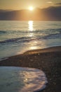 Golden splashing foamy sea waves at sunset sky and soft sun light background