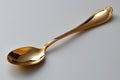 A golden spoon with a handle, with a simple design and shape on a white background Royalty Free Stock Photo