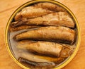 Golden sprats in open can on table