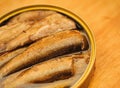 Golden sprats in open can on table