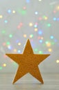 A golden star isolated against an out of focus light background Royalty Free Stock Photo
