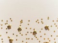 Golden stars in the form of confetti on beige background