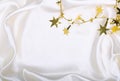 Golden stars and spangles on white silk Royalty Free Stock Photo