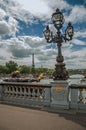 Golden statue and lighting post adorning the Alexandre III bridge over the Seine River and Eiffel Tower in Paris. Royalty Free Stock Photo