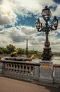 Golden statue and lighting post adorning the Alexandre III bridge over the Seine River and Eiffel Tower in Paris. Royalty Free Stock Photo