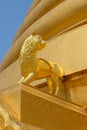 Golden statue of a lion at the base of the chedi buddhist temple of Wat Bowonniwet Wihan 1826. Bangkok. Thailand