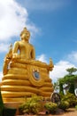 Golden statue of a sitting buddha, flanked by two Naga serpents in Thailand.