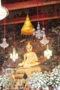 Golden Statue of Buddha surrounded by flowers, Bangkok, Thailand Royalty Free Stock Photo