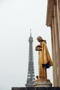 Golden statue situated in front of the iconic Eiffel Tower in Paris, France Royalty Free Stock Photo